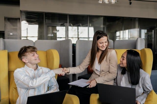 One man and two women in a conference room discussing change management and strategic initative success.